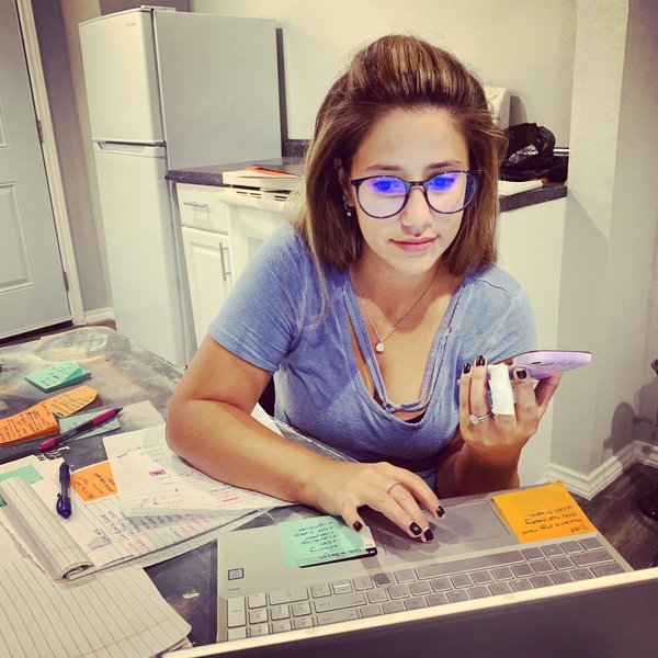 Alexa planning projects at her desk with notes and laptop